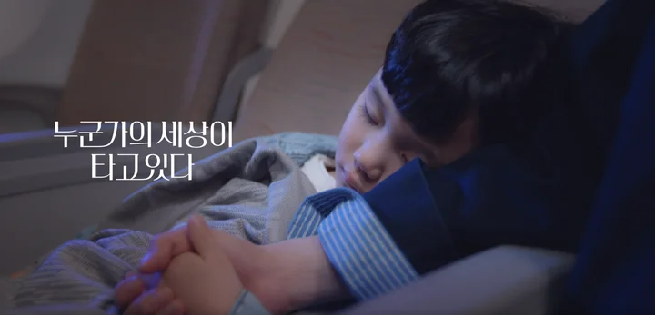 아시아나항공 광고에서 비행기 좌석에 잠든 아이 옆으로 누군가의 세상이 타고있다 문구가 뜬 브랜드 스토리텔링 장면