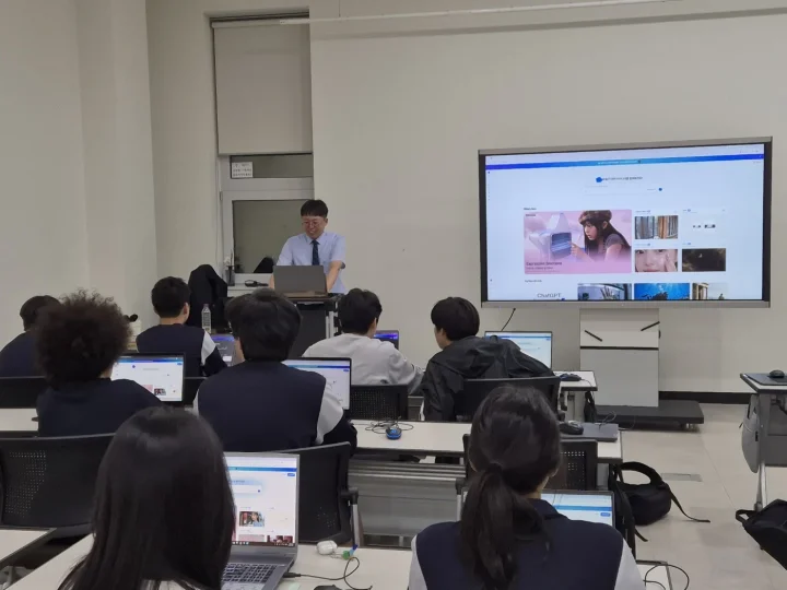교육장 대형 화면에 캐럿AI 첫 화면이 떠 있고 학생들이 각자 노트북으로 같은 화면을 열어 둔 모습