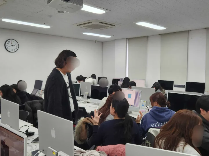 실습 중 AI 크리에이터가 학생 팀의 제작을 돕는 모습