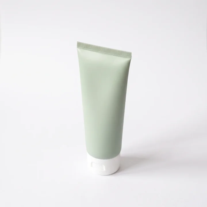 흰 배경에 세운 핸드크림 튜브를 위에서 비스듬히 내려다본 제품 사진 촬영 예시